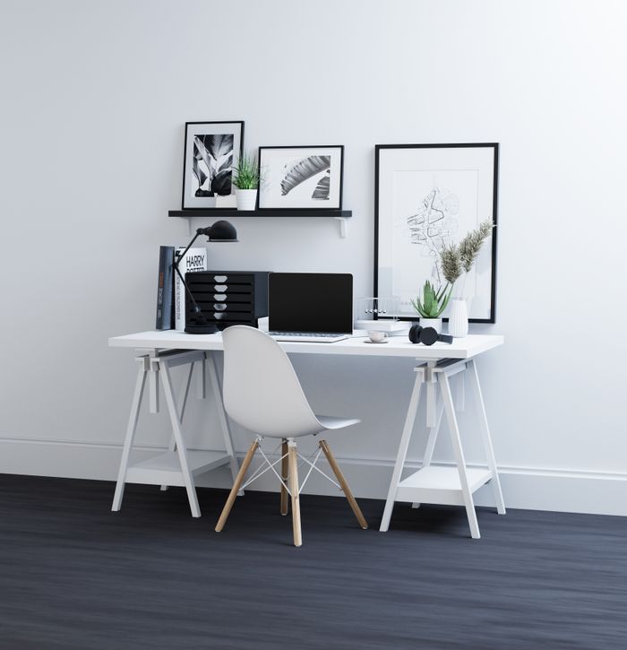 Contemporary home office featuring a minimalist desk, laptop, and stylish decor for an elegant workspace.